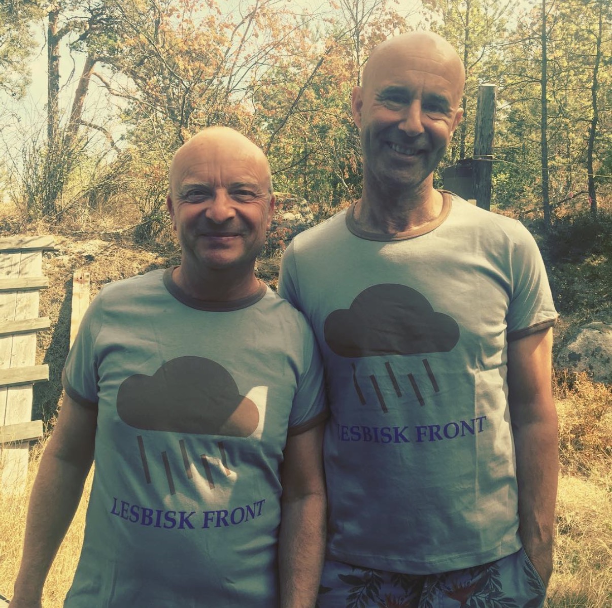 Två personer i ljusblå t-shirts med regnmoln och texten Lesbisk front